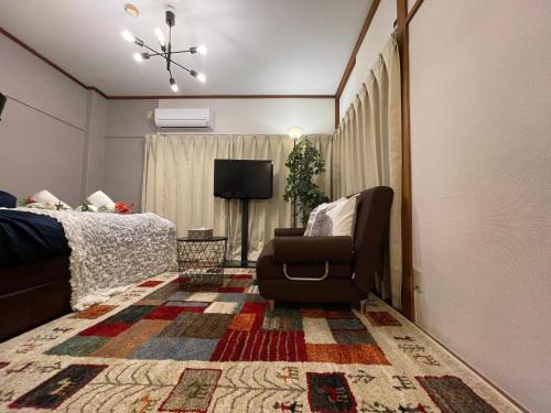 a living room with a chair and a television at Best Shinjuku Modern Full-furnished Family size Apartment4 ONLY 2min to Shinjuku by Train in Tokyo