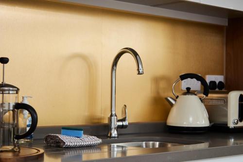 a kitchen counter with a sink and a tea kettle at Fabulous 5 Bed House w Parking in Manchester