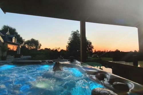a hot tub with blue lights in a backyard at The Barn - Aurora Hoeve - loft met jacuzzi in Oldekerk