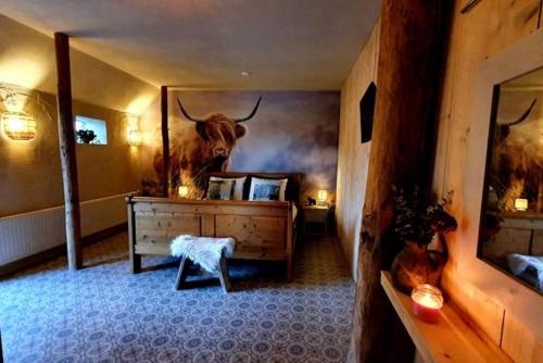 a room with a dresser with a bull on the wall at The Barn - Aurora Hoeve - loft met jacuzzi in Oldekerk