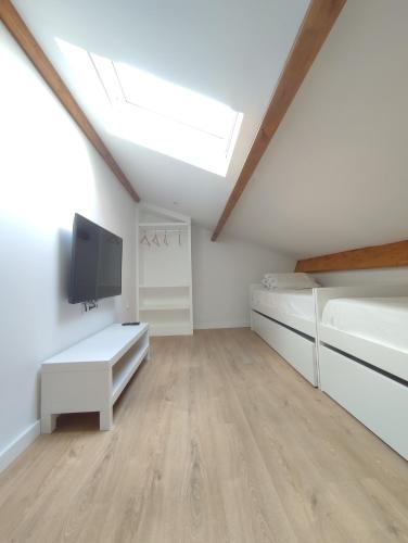 a living room with white walls and a skylight at Ocean House in Ovar
