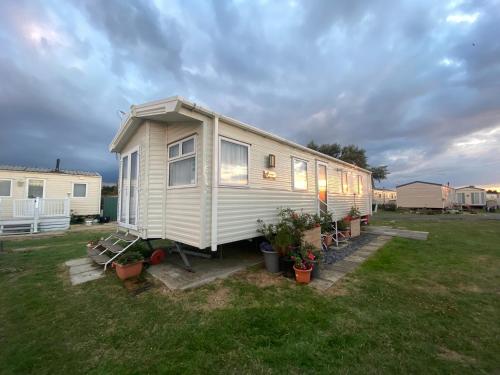 a mobile home in a yard with potted plants at Skye Breaks in Sheerness