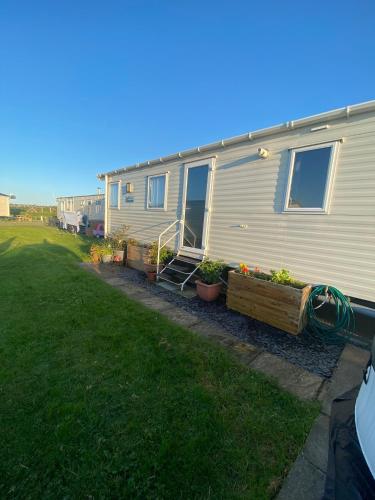 a mobile home with plants in a yard at Skye Breaks in Sheerness