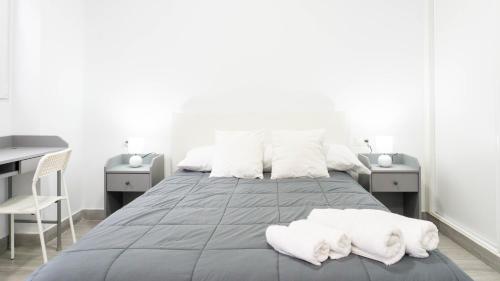 een slaapkamer met een groot bed met witte handdoeken bij Apartamento La Paloma Málaga in Málaga