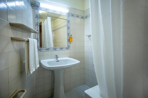 een witte badkamer met een wastafel en een spiegel bij Turial Old Town Ocean View in Albufeira