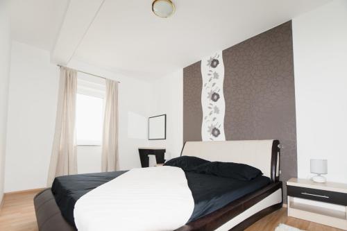 a bedroom with a white bed and a window at Apartments Toka in Petrcane