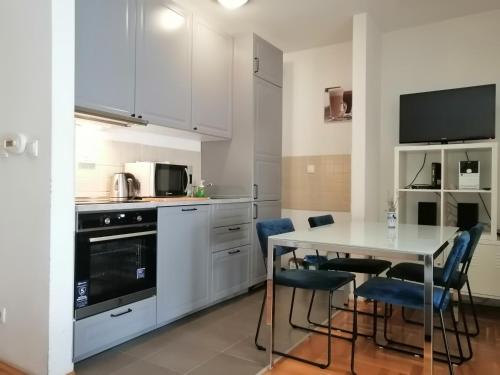 cocina con armarios blancos, mesa y sillas en Apartment Capital Town-free parking, en Zagreb