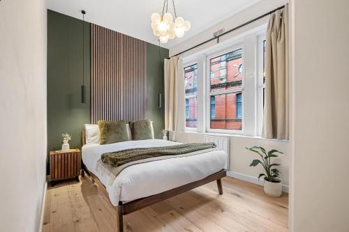Un dormitorio con una cama con paredes verdes y una ventana en Stylish 1 Bed City Centre Apartment (Sleeps 4) en Newcastle