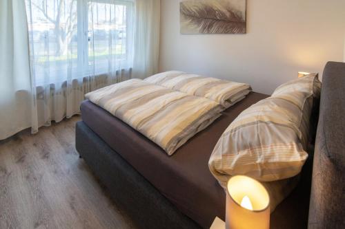 uma cama num quarto com uma grande janela em Ferienhaus Wattschnecke Norddeich em Norddeich