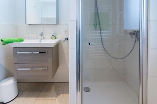 een badkamer met een douche en een wastafel bij Ferienhaus Wattschnecke Norddeich in Norddeich