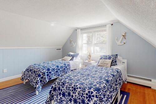 a bedroom with two beds and a window at Salty Shores in Falmouth