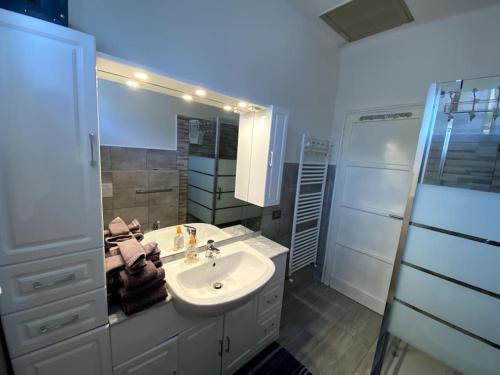 y baño con lavabo, espejo y ducha. en Casa vacanze Porto Valtravaglia Lago Maggiore en Porto Valtravaglia