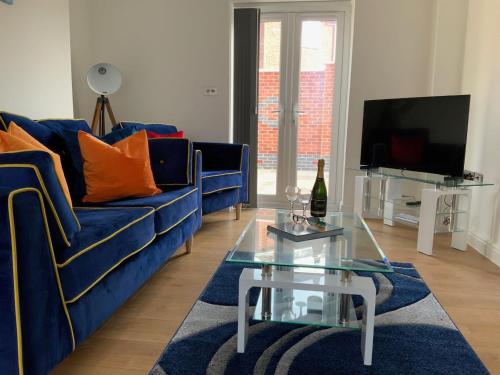 a living room with a blue couch and a glass table at London Road in Earley