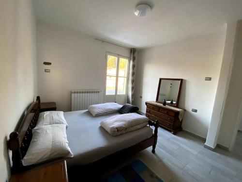 1 dormitorio con cama, tocador y espejo en Casa vacanze Porto Valtravaglia Lago Maggiore en Porto Valtravaglia