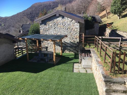 a backyard with a picnic table and a stone building at Chalet Buonriposo in Cremia