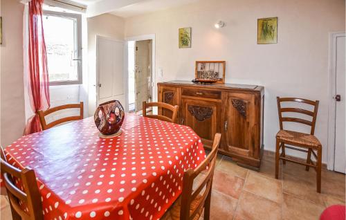 une salle à manger dotée d'une table avec un chiffon rouge et blanc de la polka. dans l'établissement Lovely Home In Malaucène With Kitchen, à Malaucène