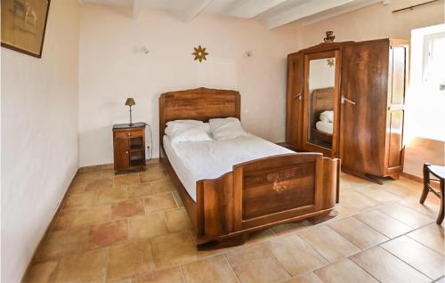 een slaapkamer met een groot houten bed en een spiegel bij Lovely Home In Malaucne With Kitchen in Malaucène