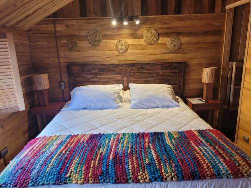 a bedroom with a bed with a colorful blanket at ALMA CHILOTA in Castro