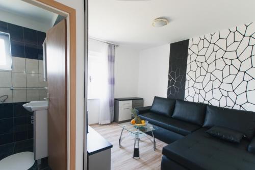 a living room with a black couch and a table at Apartments Toka in Petrcane