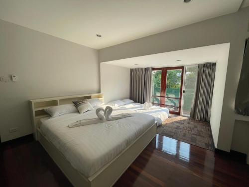 1 dormitorio con 2 camas y ventana grande en Airy Ville en Amphoe Phra Khanong