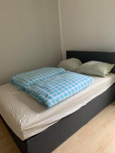 Una cama con una manta azul encima. en Apartment mit 2 Schlafzimmern in Dresdner Neustadt en Dresden