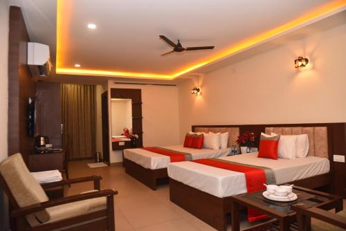 Habitación de hotel con 2 camas y mesa en M R Residency Dharwad. en Dharwad