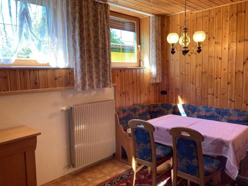 a dining room with a table and chairs and a window at Bauernhof Podorn - Ferienwohnung Panoramablick in Sankt Kanzian