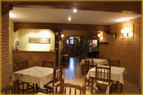 un comedor con mesas y sillas y una pared de ladrillo en CASA RUFAS (Sierra de Guara), en Bierge