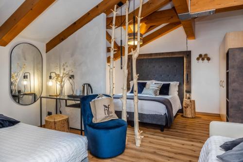 1 Schlafzimmer mit 2 Betten und einem blauen Stuhl in der Unterkunft Hotel Folgarida in Folgarida