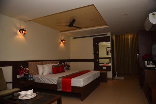 a hotel room with a bed and a couch at M R Residency Dharwad. in Dhārwād