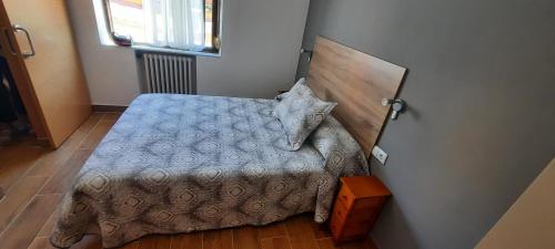 ein Schlafzimmer mit einem Bett mit einem Kopfteil aus Holz in der Unterkunft Pension La Catedral in León