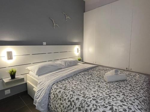 1 dormitorio con 1 cama grande con manta blanca y negra en Casa d' arte en Corfú