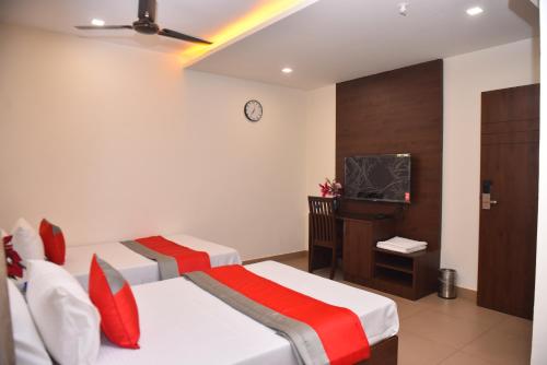 a room with two beds and a tv in it at M R Residency Dharwad. in Dhārwād