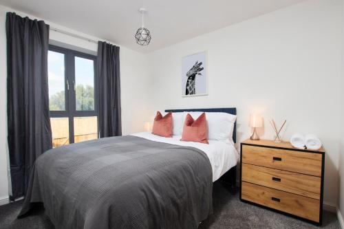a bedroom with a bed and a dresser and a window at Beaut 5 Bed House w Parking in Manchester