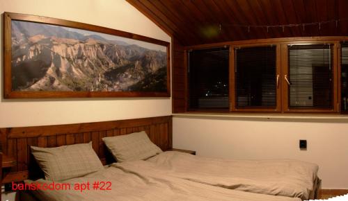 バンスコにあるBanskodomのベッド付きのベッドルーム1室、壁に山の絵画が飾られています。