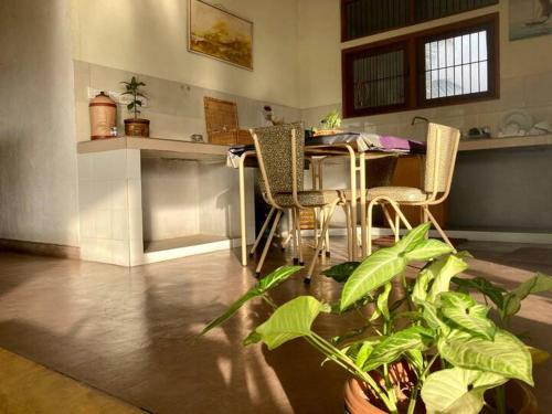 ein Wohnzimmer mit einem Tisch, Stühlen und Pflanzen in der Unterkunft Lake Round Residence in Kandy
