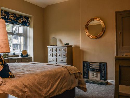 a bedroom with a bed and a mirror on the wall at Honey Cottage in Gargrave