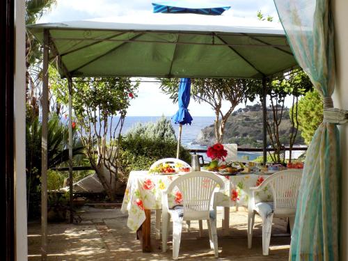 a table and chairs under a green umbrella at Le Case di Concetta in Santa Maria