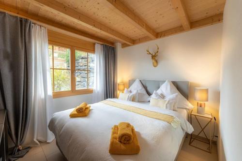 a bedroom with a large white bed with towels on it at Königin der Alpen in Beatenberg