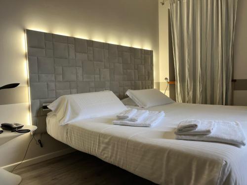 a bedroom with a white bed with towels on it at Albergo Al Cacciatore Tortellinando in Valeggio sul Mincio