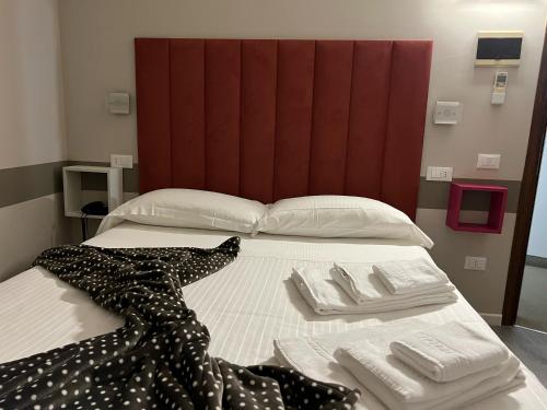a bed with a black and white dress on it at Albergo Al Cacciatore Tortellinando in Valeggio sul Mincio