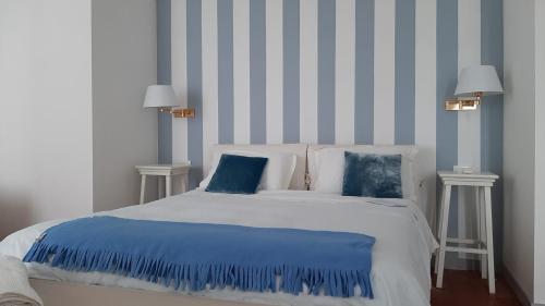 - une chambre avec un lit à rayures bleues et blanches dans l'établissement B&B Corte Vo Grande, à Pegognaga