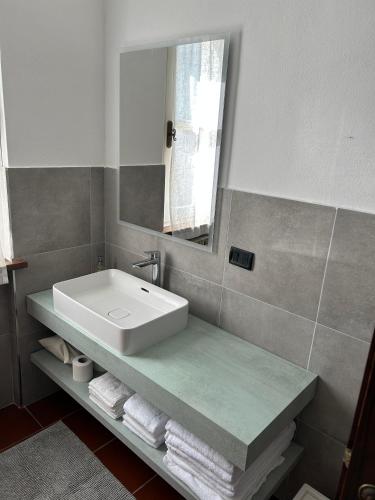 a bathroom with a sink and a mirror and towels at Case Vacanze Malonghe in Deiva Marina