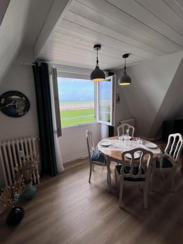 une salle à manger avec une table et des chaises et une fenêtre dans l'établissement L'air de la mer deux étoiles, à Dieppe