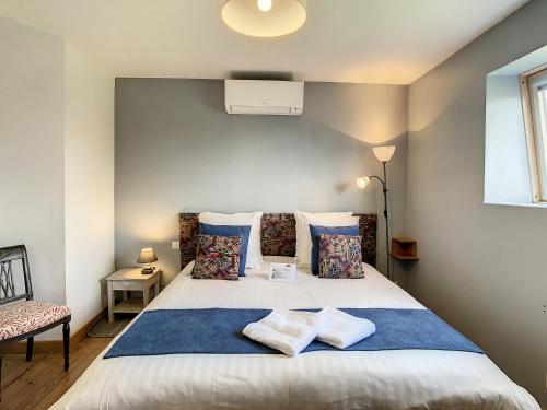 a bedroom with a large white bed with pillows at Le Chat Qui Veille in Bayeux