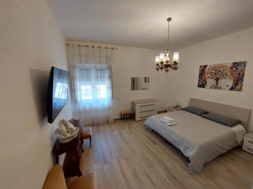 1 dormitorio con 1 cama y TV. en Da Enza, en Taranto