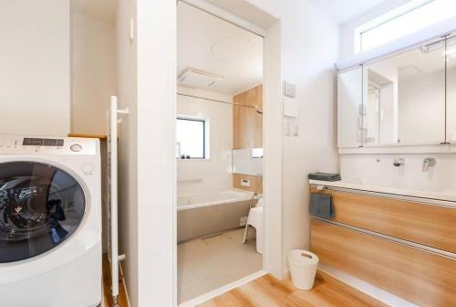 ein Badezimmer mit einer Waschmaschine und einem Waschbecken in der Unterkunft GUEST HOUSE EARTH【THE MOON & THE SUN】 in Sapporo