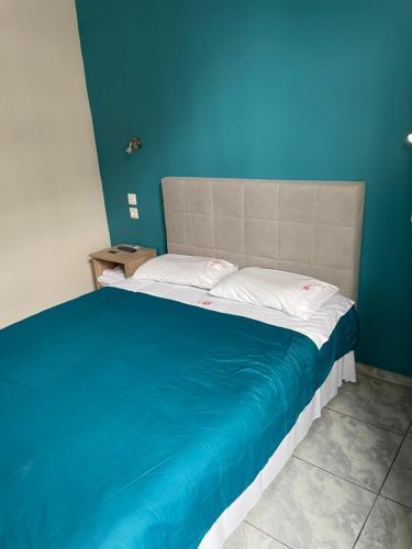 a bed in a room with a blue wall at Hotel Kastoria in Thessaloniki