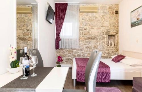 Habitación con cama y mesa con copas de vino en Rooms Palma, en Split