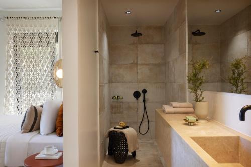 Citrus Grove Luxury Villas في سْكاليتا: حمام مع حوض استحمام وسرير ودش